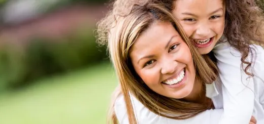 Happy mother and daughter laughing together outdoors